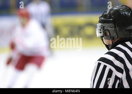 Hockey sport background - rear view of the referee against the blurry hockey game. Stock Photo