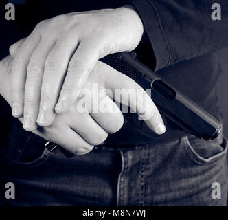 cropped shot of man holding gun in hand Stock Photo