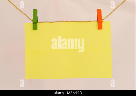 Blank sticky notes hanging with cloth pins on clothes line close view Stock Photo
