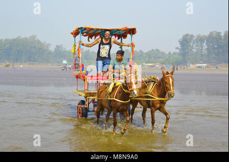 NAGAON BEACH, MAHARASHTRA, INDIA 13 JAN 2018. Tourists enjoy a horse cart ride at the Nagaon beach Stock Photo