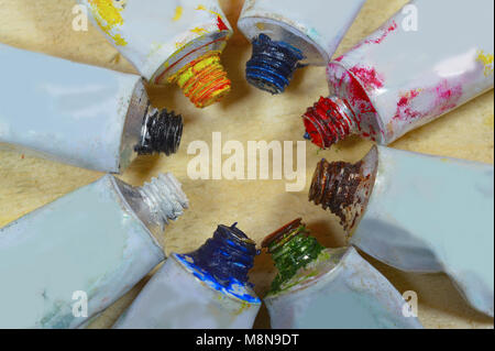 Close view of tubes of colorful paint in a circular form isolated on wooden background Stock Photo