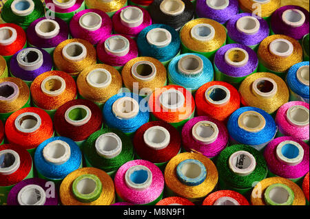 Close view of sewing threads of various color on spindles Stock Photo