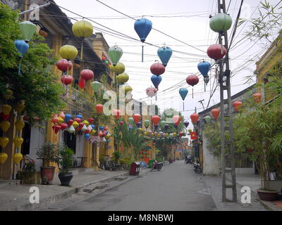 Colorful network of lanterns on the empty street of ancient town Hoi An on an early cloudy morning Stock Photo