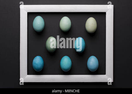 Happy Easter black and white background. DIY dyed shades of blue Easter eggs abstract minimal concept. Stock Photo