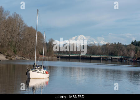 Sailboat anchored in the Bedford Channel of the Frasier River and Mt. Baker (Washington), Fort Langley, British Columbia. Stock Photo