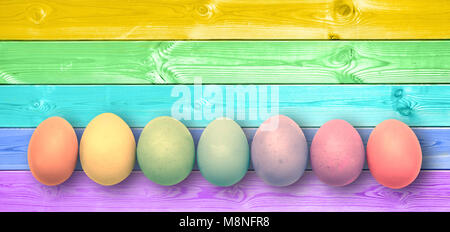 Pastel colorful rainbow painted eggs, panoramic wooden planks, easter background Stock Photo