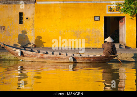 Hoi An Vietnam Old Town, view of a boat lady waiting patiently for her next customer along the quayside outside Tan Ky House in Hoi An, Vietnam. Stock Photo