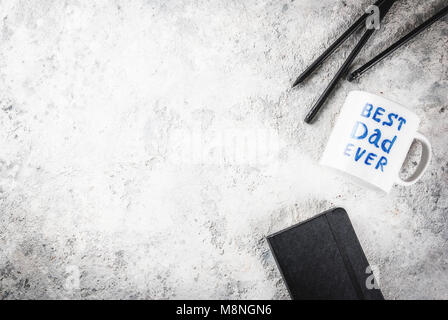 Father's Day concept, background for congratulating cards with a cup with the inscription Best Father ever, business notebook and pencils. copy space  Stock Photo