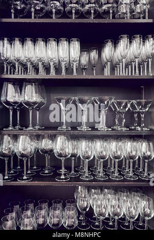 Variety of empty crystal glasses on a shelves Stock Photo