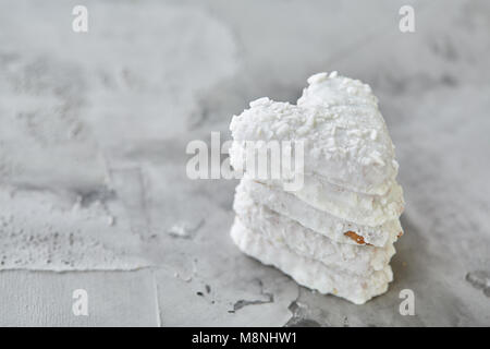 Sweet crunchy coconat heart-shaped biscuits arranged in pattern on light textured background, top view, close-up, shallow depth of field, selective fo Stock Photo