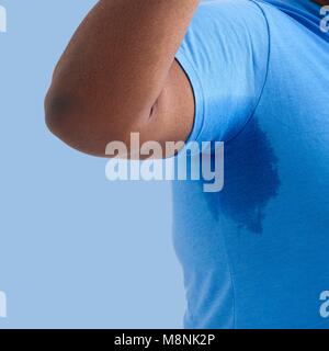 Overweight man with arm raised and sweat patch under arm. Stock Photo