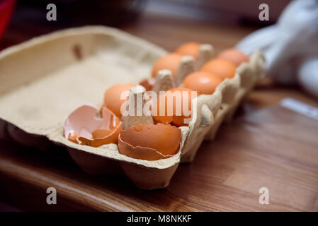 Box of chicken eggs with shells of two eggs Stock Photo
