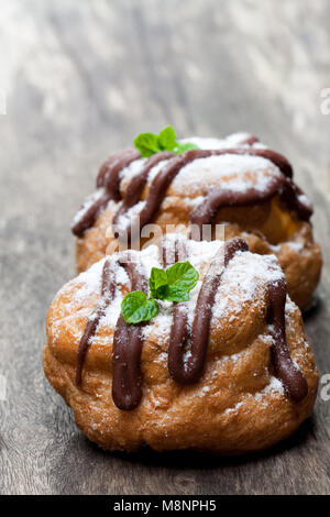 Belgian  chocolate choux buns on wooden table Stock Photo