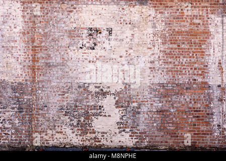 old urban industrial factory brick wall with peeling and faded paint Stock Photo