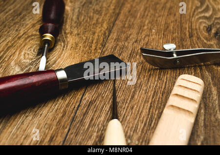 Leather craft tools on wooden background Stock Photo