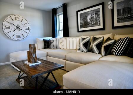 Living room with white sectional and modern decor on the walls Stock Photo