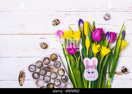 Easter flat lay composition. A bouquet of spring flowers and quail eggs. Stock Photo