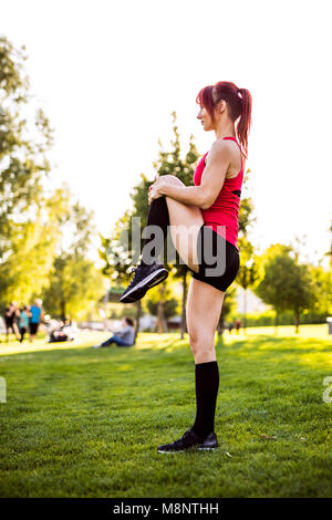 Young runner stretching and warming up in park. Stock Photo