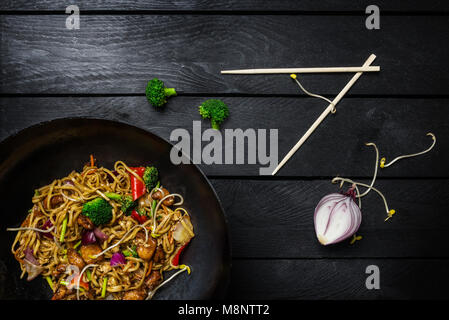 Udon stir fry noodles with meat or chicken. Served with chopsticks. Top view. Stock Photo