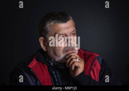 Nice low key portrait of senior man thinking about life problems Stock Photo