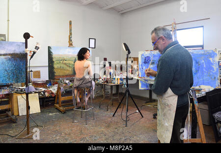 painter painting a model in the studio Stock Photo