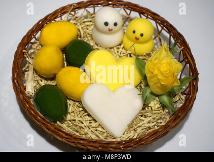 Easter decoration, chicken, hearts and eggs made from marzipan in the basket Stock Photo