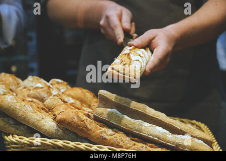 men's hands cut bread for sandwiches, sandwich blanks. Stock Photo