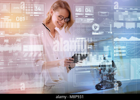 Positive engineer holding a modern tablet while testing a new robot Stock Photo