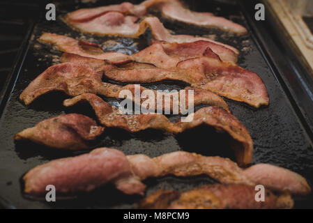 A close up for bacon sizzling on a griddle. Stock Photo