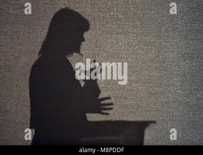 silhouette of female speaker at podium Stock Photo