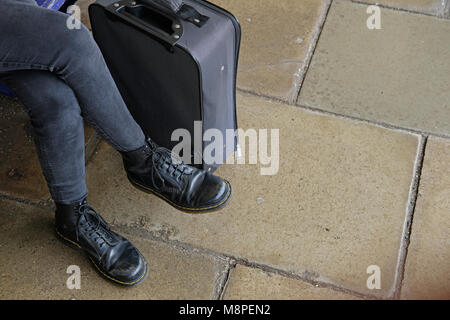 Student wearing Dr Martin shoes with her suitcase. Stock Photo