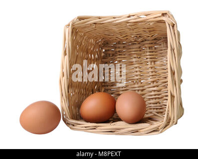 Two eggs in a basket and one separately isolated on white Stock Photo