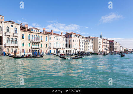 Busy gondola traffic with tourists sightseeing on the Grand Canal and St Marks Basin, San Marco, Venice, Veneto, Italy on a sunny blue sky day at the  Stock Photo
