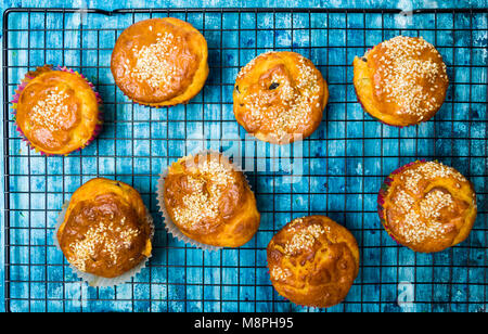Homemade sesame muffins with seeds and grains on a baking net Stock Photo