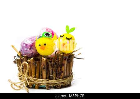 Toy chicken and Easter eggs in wicker nest isolated Stock Photo