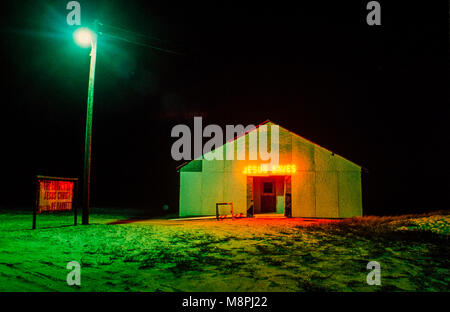 Small church in rural south Georgia is illuminated by a streetlight and a Jesus Saves sign Stock Photo