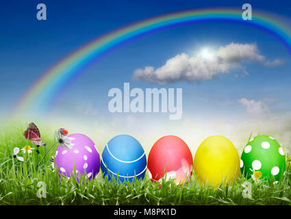 Easter eggs, dyed, with a pattern on the background of a sunny sky in the grass Stock Photo