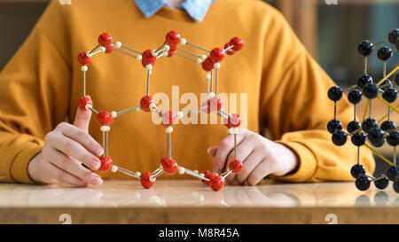 Unrecognisable female student holding molecular structure model. Science class concept. Stock Photo