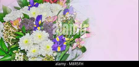 Festive colorful floral border with bouquet of different flowers: pink alstroemeria, white chrysanthemums, blue irises close up with copy space for te Stock Photo