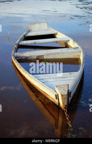Wooden boat on the bank of the flooded river Stock Photo - Alamy