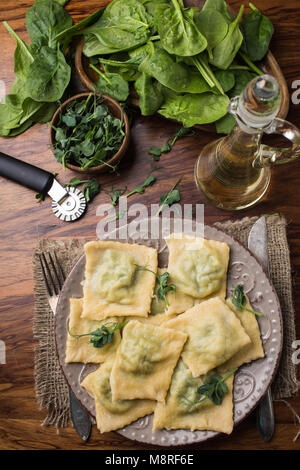 ready ravioli in a plate, spinach, olive oil in a jar. Stock Photo