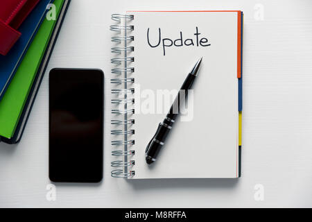 Update - handwritten text in a notebook on a desk. Project update checklist. Notebook, pen and books Stock Photo