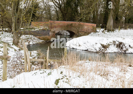 A snowy winter scene of the River Sence passing under a road bridge shot at Newton Harcourt, Leicestershire, England, UK. Stock Photo