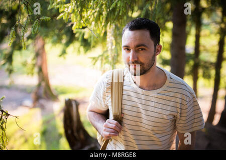 Smiling happy handsome man with beard in forest, mountains, park. Traveler Man relaxing . Travel Lifestyle hiking concept summer vacations outdoor. Bearded man. Stock Photo