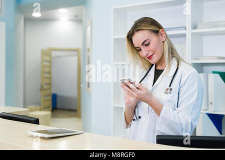smiling female Doctor use the cell phone, concept of medical worker Stock Photo