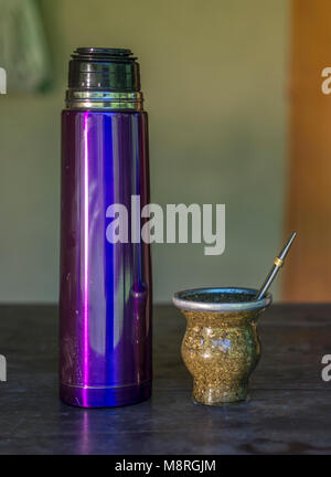 Mate of glass and violet thermo, typical Latin American infusion, on wooden table Stock Photo