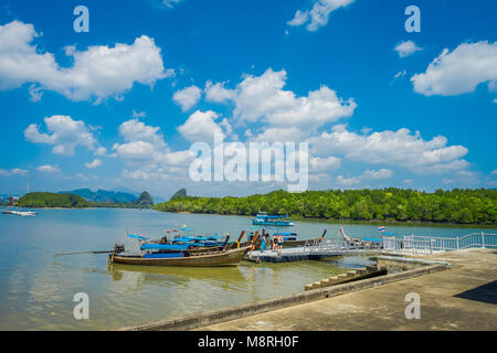 AO NANG, THAILAND - FEBRUARY 19, 2018: Outdoor view of long tail fishing boats in the riverside close to metallic structure in the pier located in the river at Krabi Province, South of Thailand Stock Photo