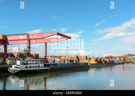 Gennevilliers, France - March 11, 2018: A barge loaded with containers is docked in the intermodal terminal, run by the company Paris Terminal, in the Stock Photo