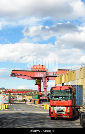 Gennevilliers, France - March 11, 2018: A red semi-trailer truck parked near the road access to the intermodal terminal in the Gennevilliers port, fir Stock Photo