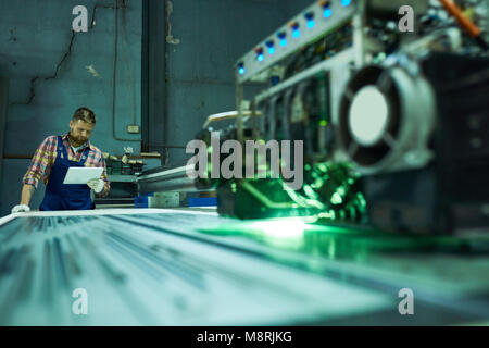 Worker Operating Engraving Machine Stock Photo